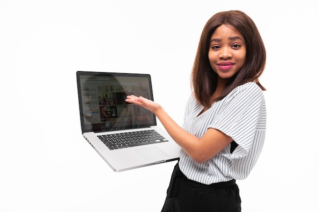 Smilling dunkelhäutiges Geschenk smth des jungen Mädchens der Laptop an lokalisiert