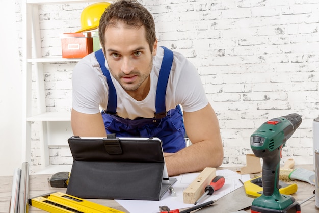 Smilling joven usando la tableta para bricolaje