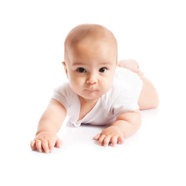 Smily Baby Boy liegt auf dem Bauch auf weißem Hintergrund