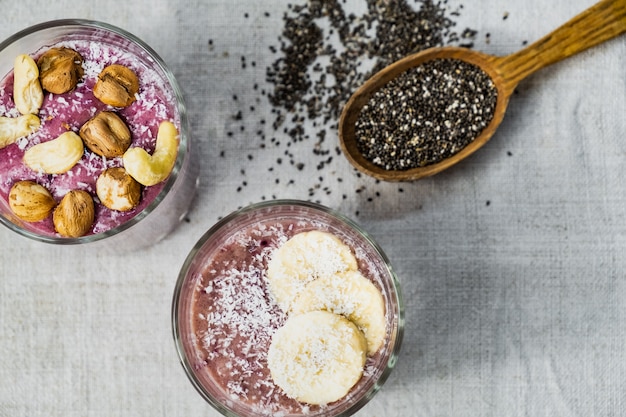 Smoothie Bowl desayuno, disparó desde arriba. Comidas orgánicas saludables de alimentos crudos en superficie rústica natural