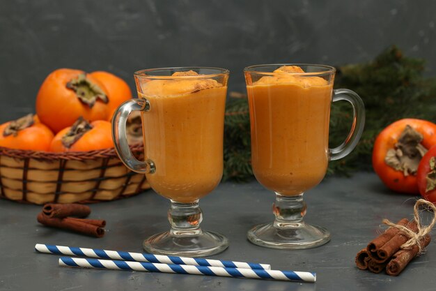 Smoothie caseiro de caqui com canela em fundo escuro