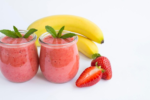 Smoothie com morango e banana na jarra de vidro no fundo branco Copiar espaço Closeup