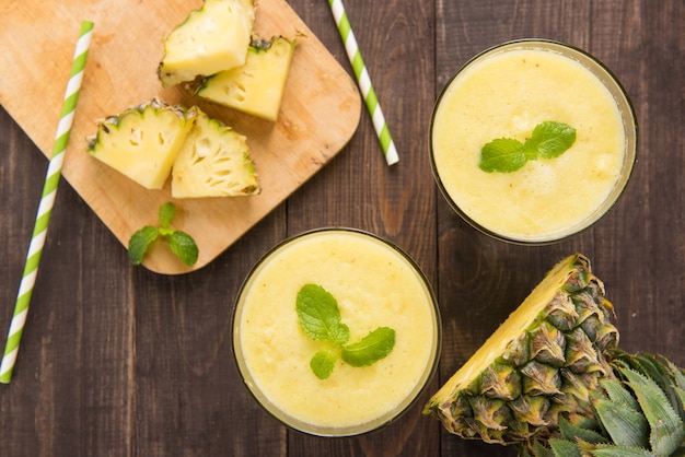 Smoothie de abacaxi com abacaxi fresco na mesa de madeira