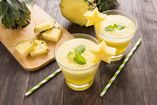 Smoothie de abacaxi com abacaxi fresco na mesa de madeira