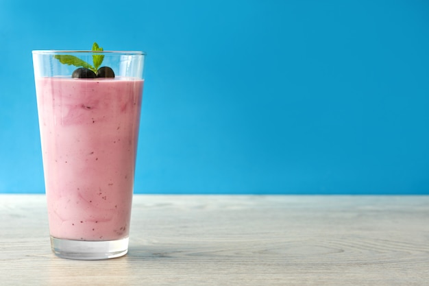 Smoothie de amora fresca em vidro na mesa de madeira branca