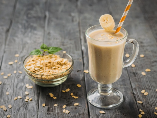 Smoothie de banana com aveia em uma mesa de madeira