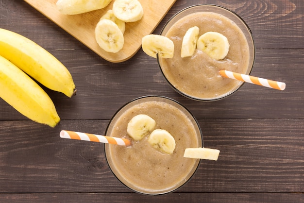 Smoothie de banana tiro superior em fundo de madeira