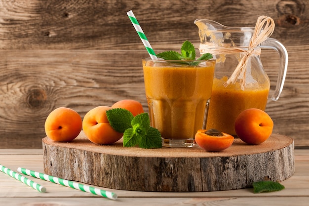 Smoothie de damasco fresco e frutas em fundo de madeira