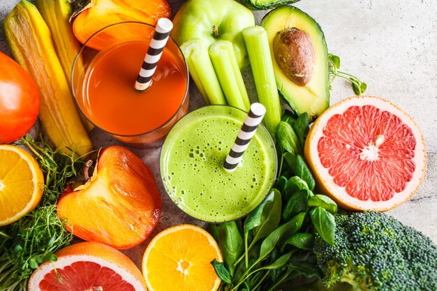 Foto smoothie de desintoxicação verde e laranja em vidro. ingredientes para o fundo de smoothie de desintoxicação. conceito de comida saudável.