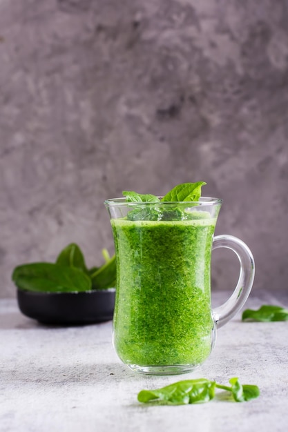 Smoothie de espinafre fresco em um copo e uma tigela com folhas Antioxidante natural Visão vertical