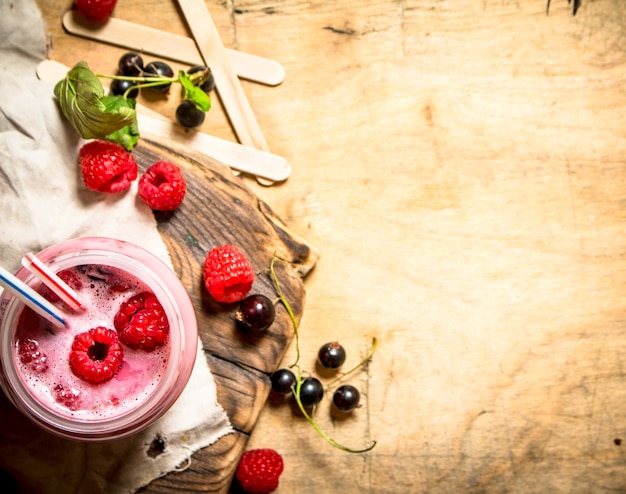 Smoothie de framboesa e groselha preta. Em fundo de madeira.