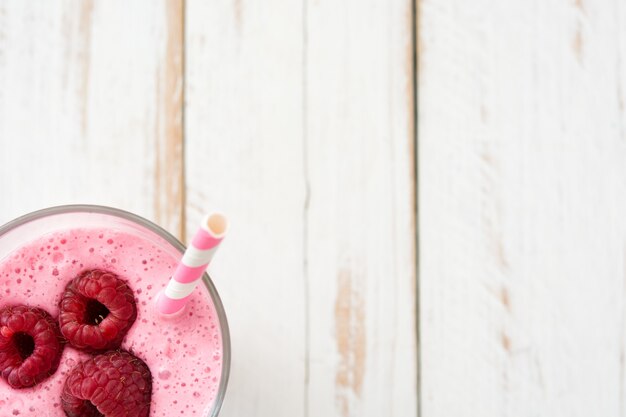 Smoothie de framboesa em vidro na mesa de madeira branca