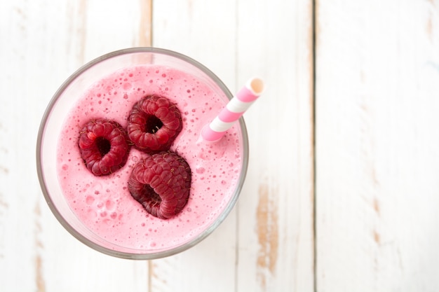 Smoothie de framboesa em vidro na mesa de madeira branca