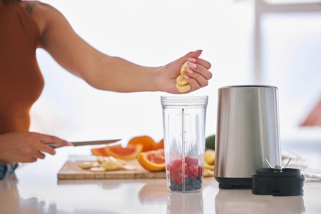 Smoothie de frutas e manhã com mãos de mulher na cozinha para dieta de saúde intestinal e café da manhã Desintoxicação de bem-estar e nutrição com close-up de pessoa do sexo feminino em casa para cozinhar suco e perda de peso