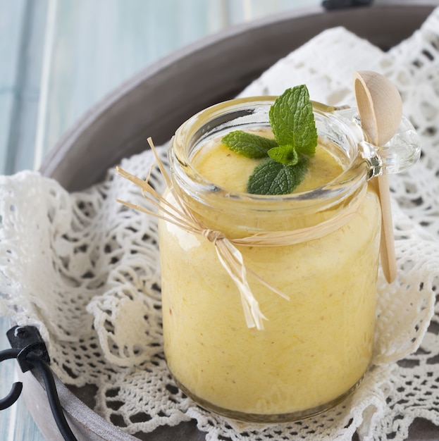 Smoothie de frutas saudável e fresco de laranja e tâmara na mesa de madeira azul