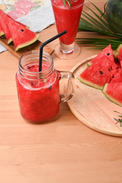 Smoothie de melancia fresca em frasco de vidro na mesa de madeira.