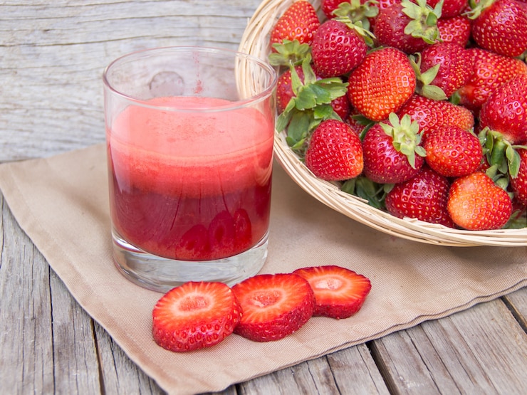 Foto smoothie de morango fresco suco e morangos em uma mesa de madeira fechar