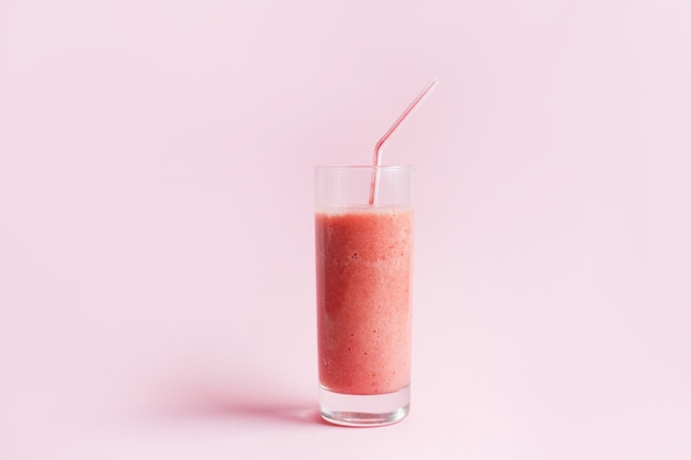 Smoothie de morango ou milkshake em frasco de vidro em fundo rosa pastel. Alimentos saudáveis no café da manhã e lanche.