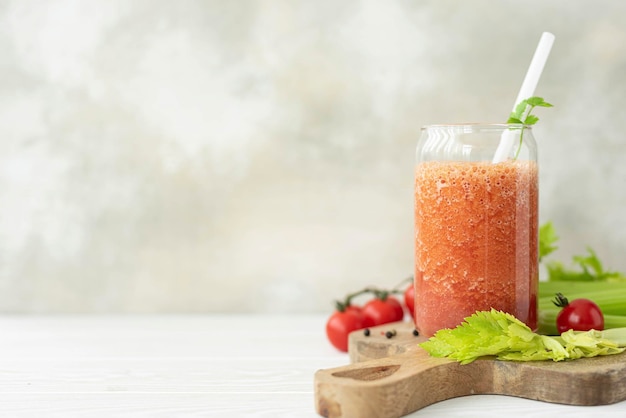 Smoothie de vegetais frescos de tomate e aipo em uma jarra de vidro closeup