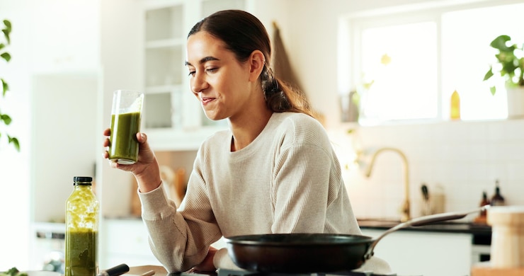 Foto smoothie feminino e bebida na cozinha para nutrição saudável e pequeno-almoço com cozinha matinal sorriso nutricionista e suco saudável em casa para perda de peso de bem-estar ou desintoxicação com shake suplemento