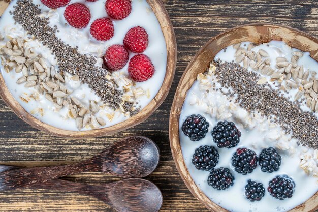 Smoothie in Kokosnussschale mit Brombeeren, Himbeeren, Haferflocken, Sonnenblumenkernen und Chiasamen zum Frühstück aus nächster Nähe Das Konzept der gesunden Ernährung Superfood