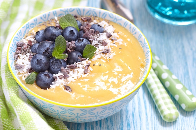 Smoothie mit Mango, Orange und Banane, dekoriert mit Blaubeeren