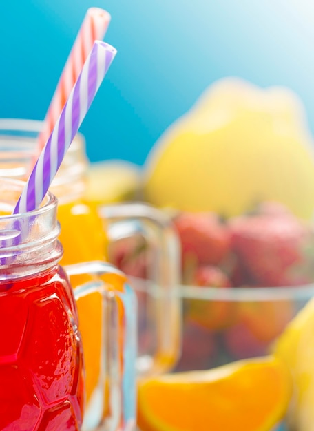 Foto smoothie de piña y fresa en vasos con frutas sobre un fondo rústico de madera azul