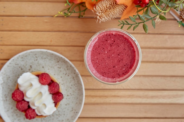 Smoothie rosa saudável torta de framboesa estética francesa e decorações de outono na mesa de madeira Vista superior