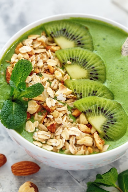 Smoothie-Schüssel mit Spinat, Kiwi und Nüssen für ein gesundes Frühstück