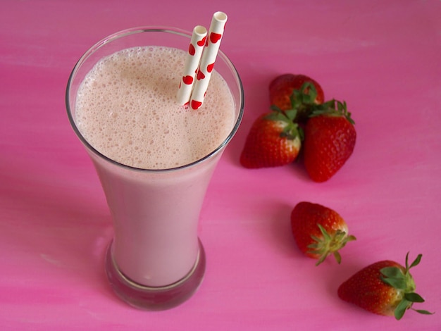 Foto smoothie en vaso con fresas en la mesa