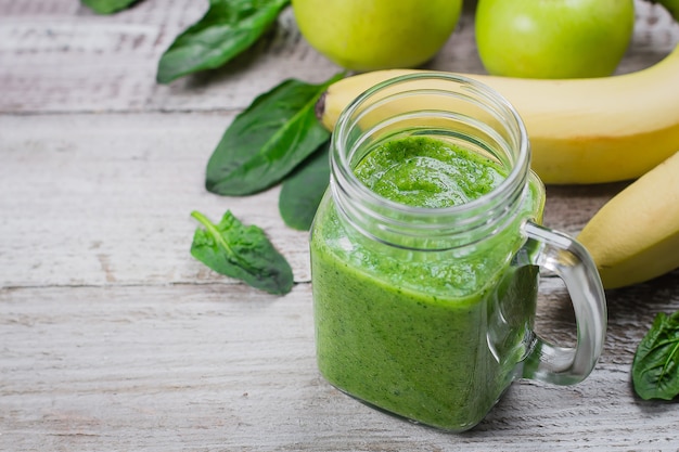 Smoothie verde em pote com folhas de maçã, banana e espinafre