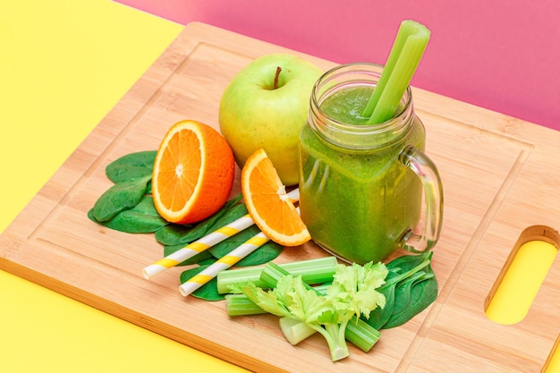 Smoothie verde fresco de maçã, aipo, espinafre e laranja em frasco de vidro de smoothie