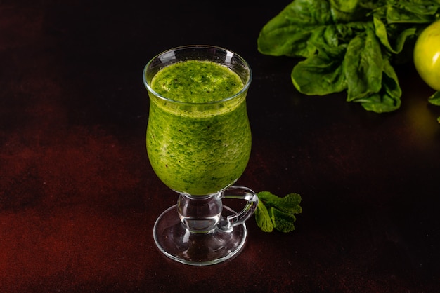 Smoothie verde de la manzana del jengibre en fondo concreto.