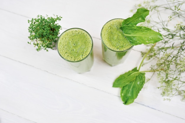 Smoothie verde misturado com ingredientes em branco