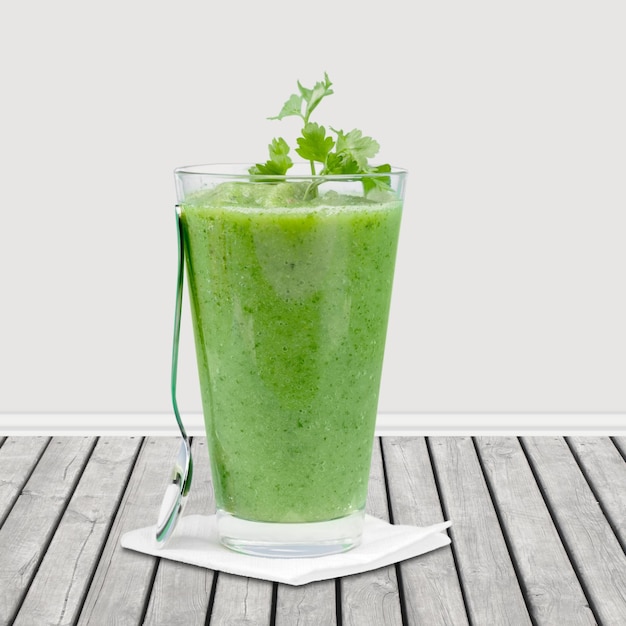 Smoothie verde saudável delicioso com frutas e vegetais na mesa