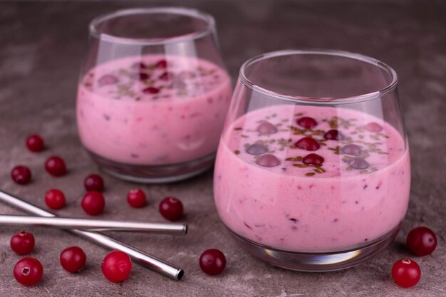 Smoothies de cranberry frescos em copos em um fundo cinza