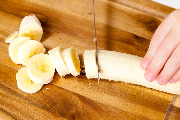 Smoothies machen mit gelber Banane, in Scheiben geschnittene gelbe reife Banane