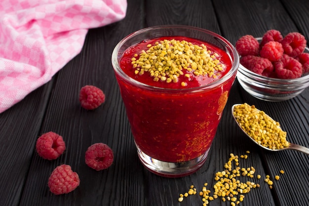 Smoothies mit Himbeeren und Bienenpollen auf dem schwarzen hölzernen Hintergrund