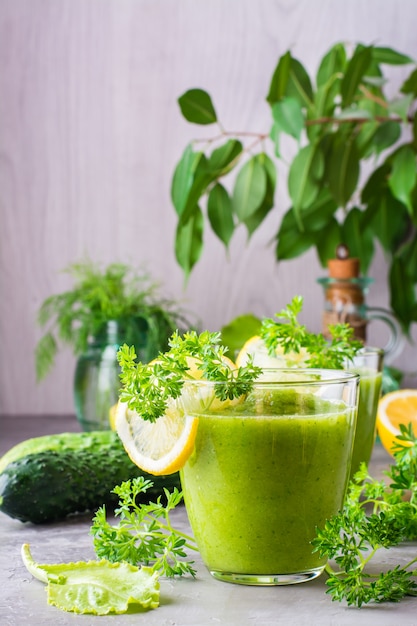 Smoothies refrescantes de pepino, maçã verde, ervas frescas e suco de limão em copos transparentes na mesa