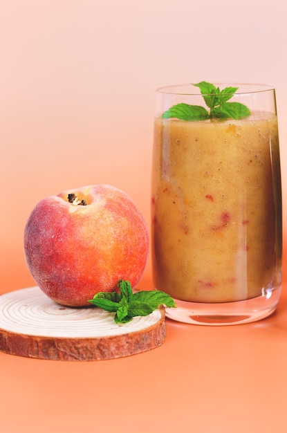 smoothies saudáveis frescos em um copo feito de pêssego, banana, frutas com hortelã. bebida desintoxicante saudável