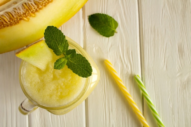 Smoothies von Melone auf dem weißen hölzernen Hintergrund. Draufsicht.