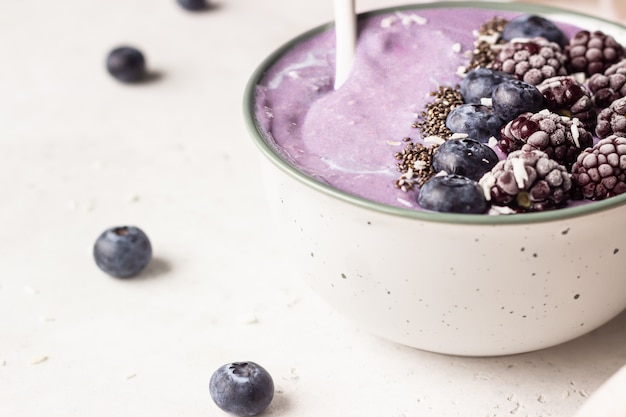 Smoothieschüssel mit Beeren, Chiasamen und Kokosflocken