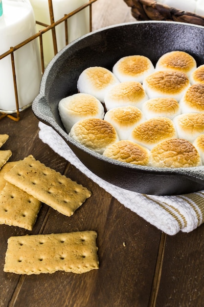 Smores Dip zubereitet mit großen Marshmallows in einer gusseisernen Pfanne.