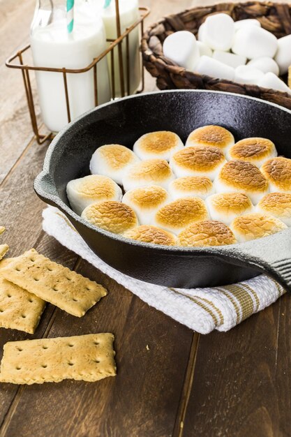 Smores Dip zubereitet mit großen Marshmallows in einer gusseisernen Pfanne.