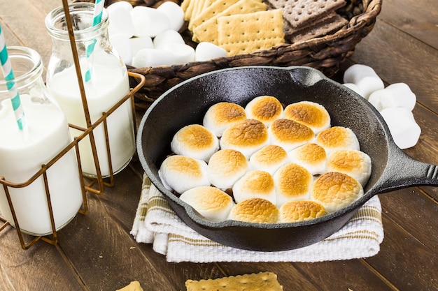 Smores Dip zubereitet mit großen Marshmallows in einer gusseisernen Pfanne.