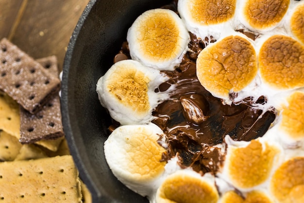 Smores mergulho preparado com grandes marshmallows em panela de ferro fundido.