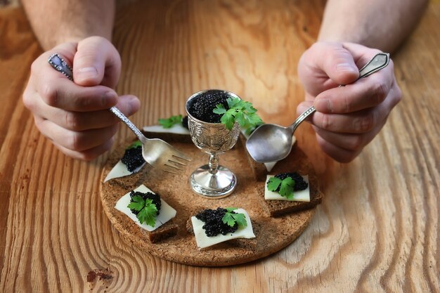 Snack caviar negro sobre un fondo marrón de madera