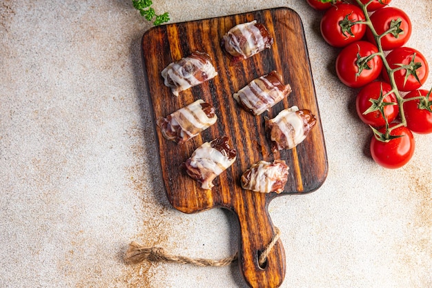 Snack Datteln in Speck geräuchertes Fleisch trocken gepökelte Mahlzeit Essen Snack auf dem Tisch Kopie Raum Essen Hintergrund