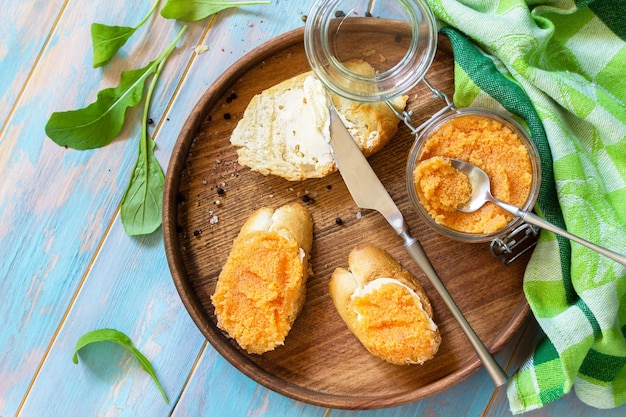 Foto snack oder frühstück sandwiches mit butter und gesalzenem kaviar auf einem hölzernen küchentisch draufsicht