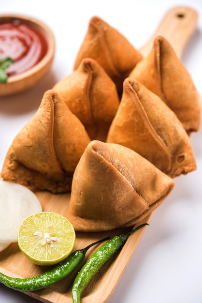 Snack Samosa servido con salsa de tomate y chutney de menta